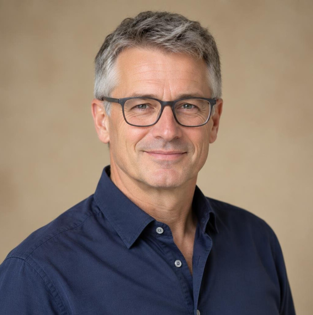 Studio portrait of a middle-aged Swiss man with glasses, editor-in-chief